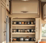 Husbilskök med öppet skafferi – välorganiserade hyllor med burkar, glas och kastruller i modernt husbilsinteriör