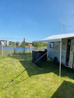 Husbil med utfälld markis och sidoskärm på campingplats vid vatten – perfekt för husvagn och camping