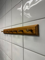 Väggmonterad trähängare med krokar på kakelvägg – praktisk krokrad för husbil, husvagn och hemmet