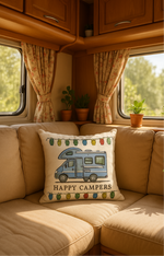 Kuddfodral med husbilsmotiv och texten Happy Campers på soffa i husbil.