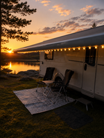 Nova Markisbelysning tänd längs husvagnens markis vid solnedgång intill en sjö – stämningsbelysning för camping