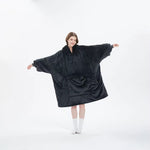Dam i mörkblå oversized hoodie-filt med armarna utsträckta som visar storleken, vit bakgrund – camping.