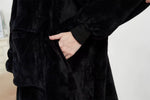Närbild av hand i fickan på svart oversized hoodie-filt, vit bakgrund – camping.