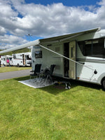 Husbil med markis utfälld på campingplats, monterad med skruvfritt markishållare och sugkopp.