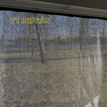 Solskydd för husbil sett inifrån, visar meshmaterialets genomskinlighet med utsikt mot naturen utanför.