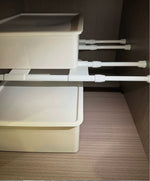 Vita justerbara spännskenor håller förvaringslådor på plats i skåp i husbil eller husvagn.