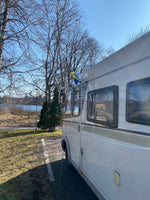 Svensk bilflagga monterad på husbil, perfekt dekoration för camping och resor i Sverige.